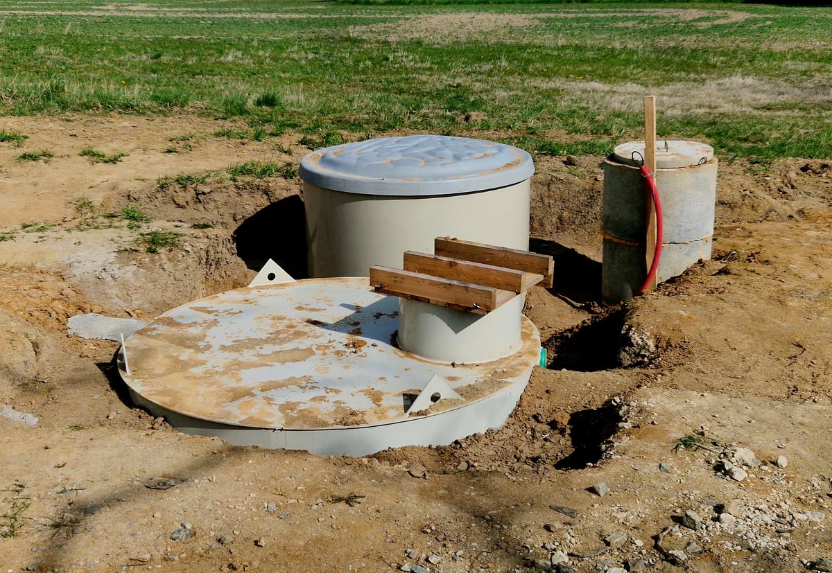 Installation of concrete tanks painted with black insulating asphalt paint. the ring entrances look over the terrain otherwise everything is underground. rainwater retention tank